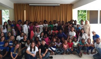 Parte del personal y estudiantes de UNIBE, junto a las niñas y los miembros del hogar infantil.